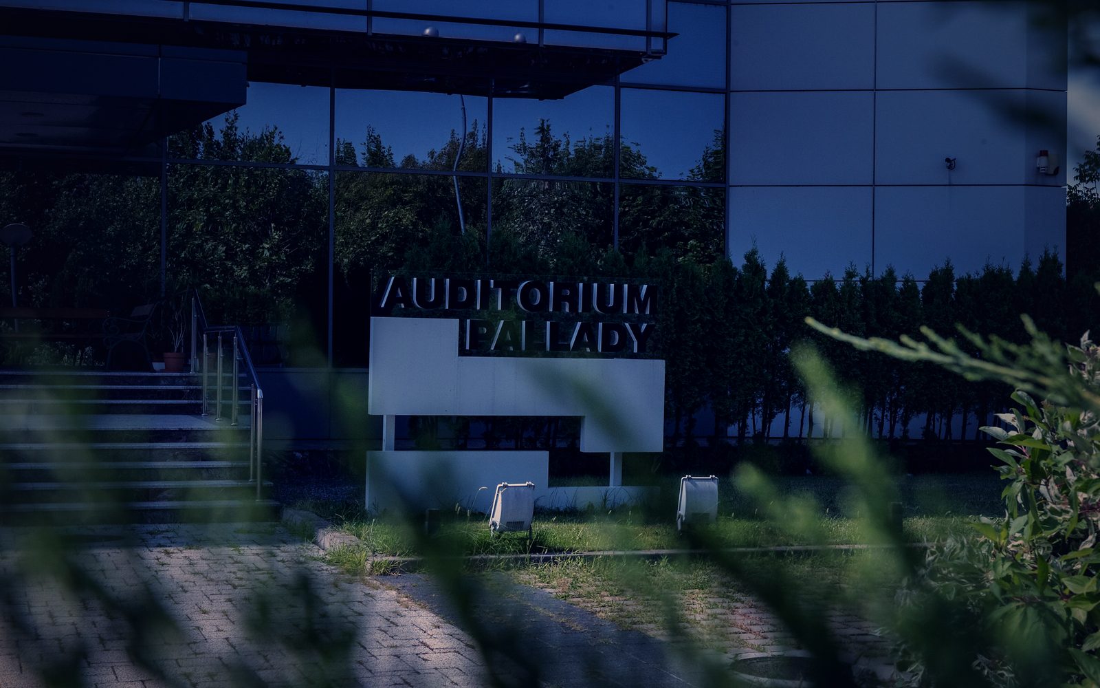 Firma clădirii, cu literele AUDITORIUM PALLADY montate pe un panou alb, lângă treptele de la intrare.